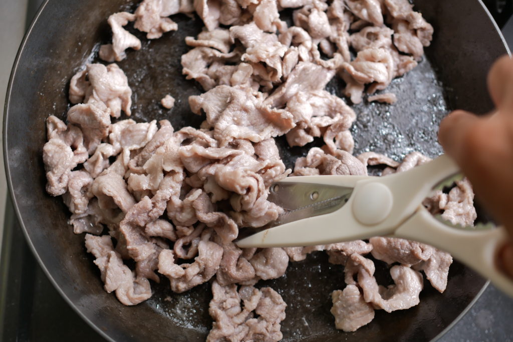 豚こま肉をハサミで切る